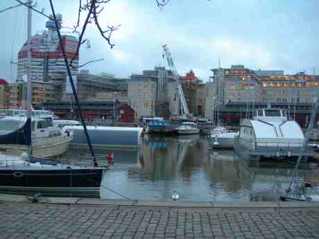 Ensam svan vänder stolt eleganta nacken åt långhalsade mobila julbockskranen. Onsdag 19 december 2012 kl 15.17.