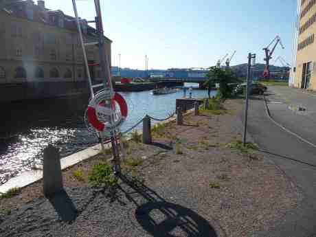 Paddan 11 kommer från Inre Järnvågsbron in i Rosenlundskanalen och passerar optimistiska metare vid Rosenlunds kraftvärmeverk med Lagerhuset mitemot. Torsdag 20 juni 2013 kl 18:10.