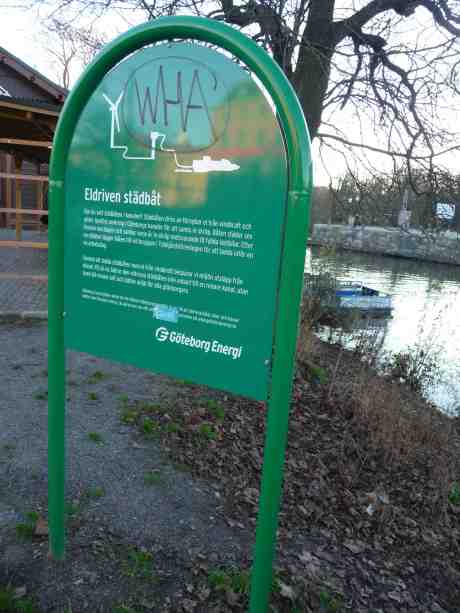 Eldriven städbåt skymtar i Vallgraven vid Trädgårdsföreningen och Slussbron. Söndag 24 november 2013 kl 14:55.
