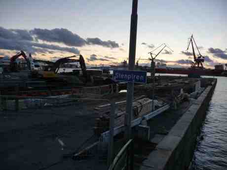 Kvällsarbete för grävskoporna på Stenpiren. Vid Götaverken på andra sidan Göta älv ligger M/S Primula. Torsdag 26 september 2013 kl 19:07.