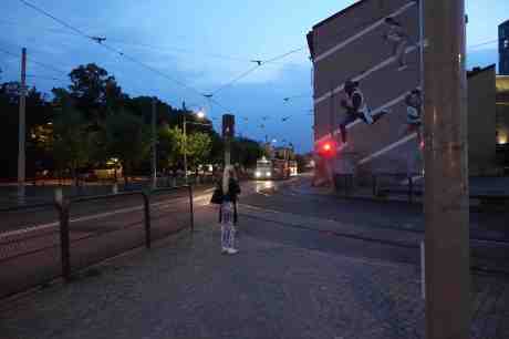 I väntan på att spårvagnen ska passera framför väggmålningen från friidrotts-VM 1995. Torsdag 7 augusti 2014 kl 21:50.