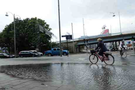 Cyklisterna riskerar att bli blöta om pedalfötterna efter skyfallet. Kanaltorgsgatan tisdag 19 augusti 2014 kl 17:44.